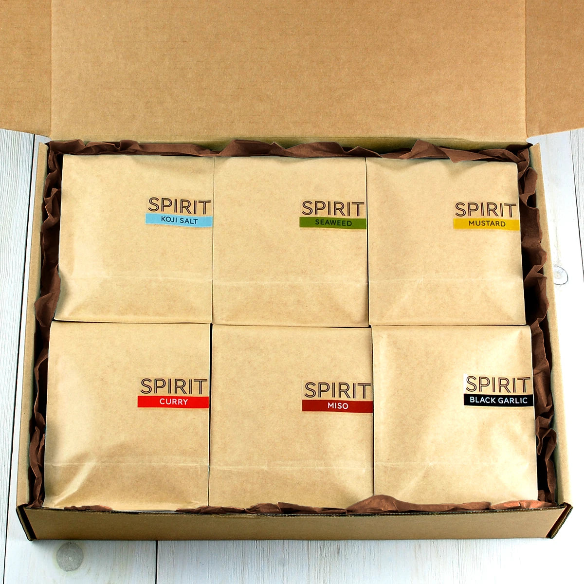 SPIRIT Almond MEGA Pack with six pouches as seen inside gift box with brown tissue paper