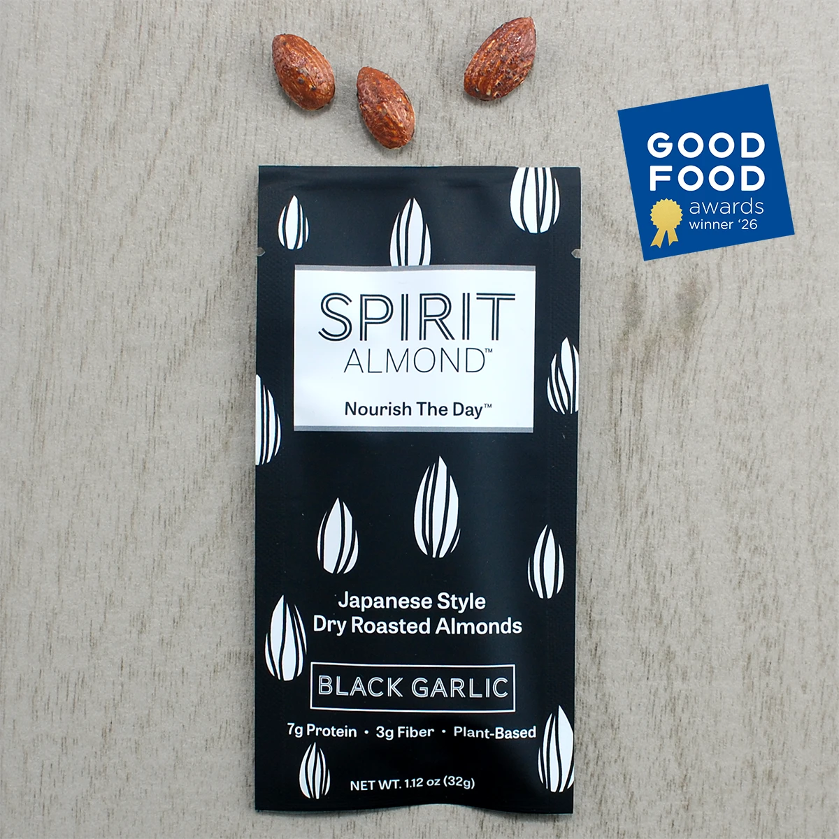 Black Garlic Spirit Almond package with almonds and Good Food Award Winner badge on a wooden surface