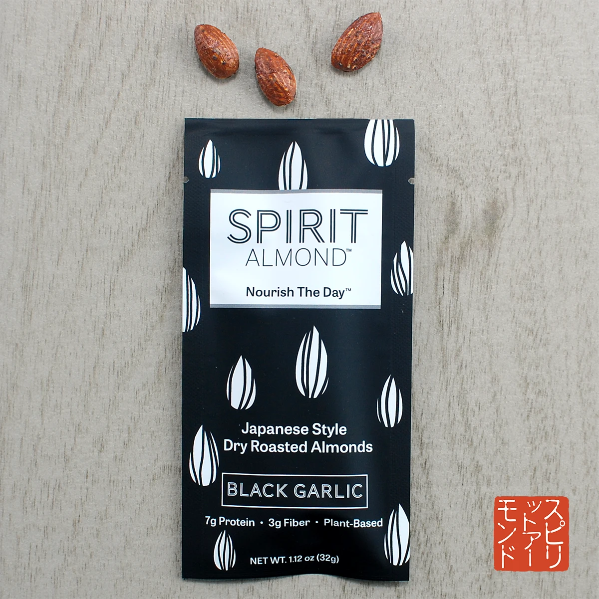 Package of SPIRIT Almond Black Garlic flavor, with a few almonds displayed