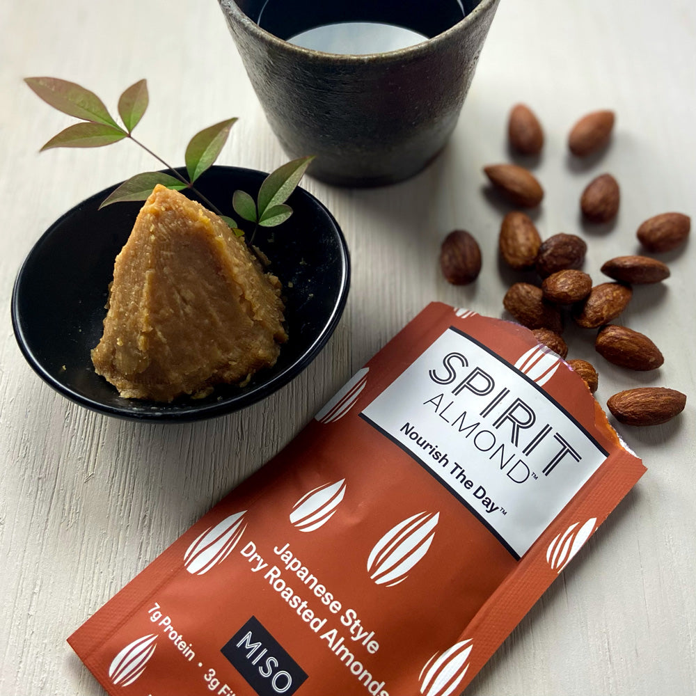 SPIRIT Almond Japanese Style Dry Roasted Almonds Miso flavor in single serving bag next to plate of miso..