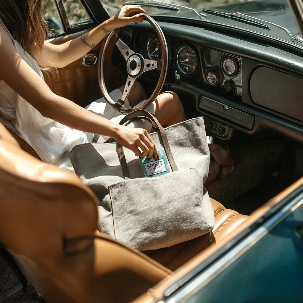 Woman in car reaching for a package of SPIRIT Almond
