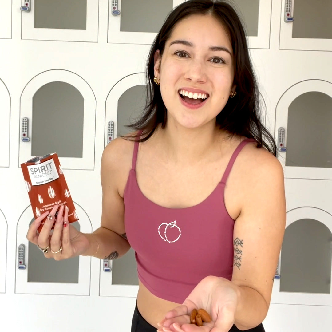 Smiling woman in gym clothes with SPIRIT Almond
